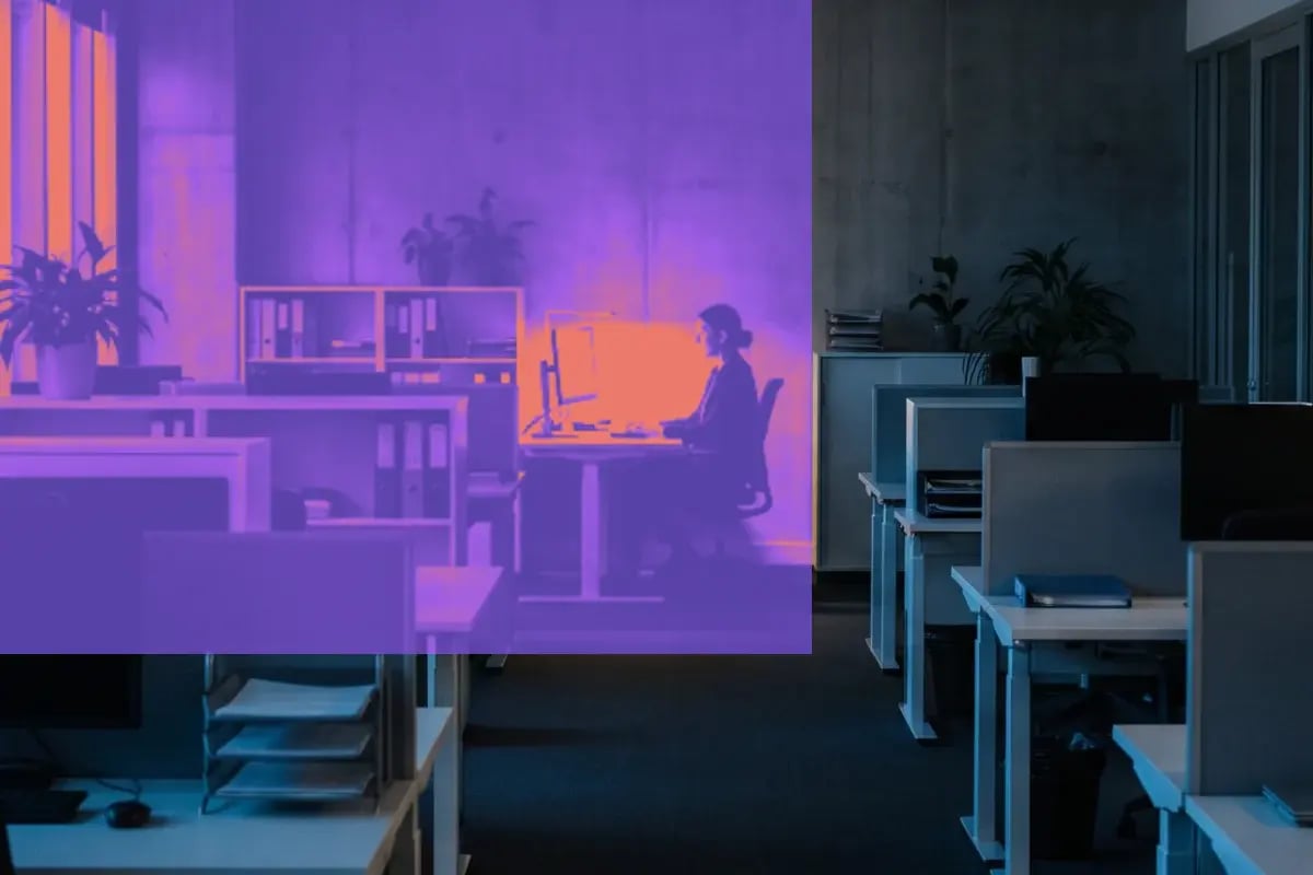 Employee signing in at a desk in an open-plan office