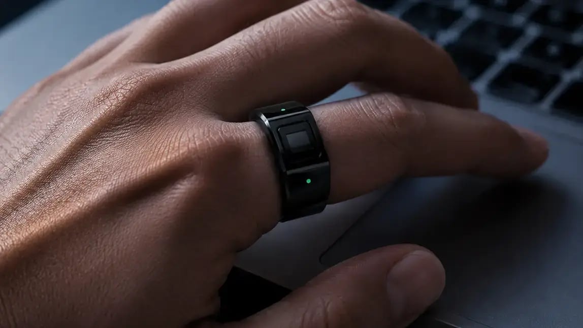 Close-up of a Token Ring with active status lights on a hand above a laptop trackpad